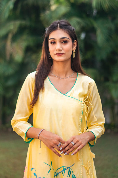 Close-up of an Indian model wearing a yellow angrakha kurta with resham embroidery.