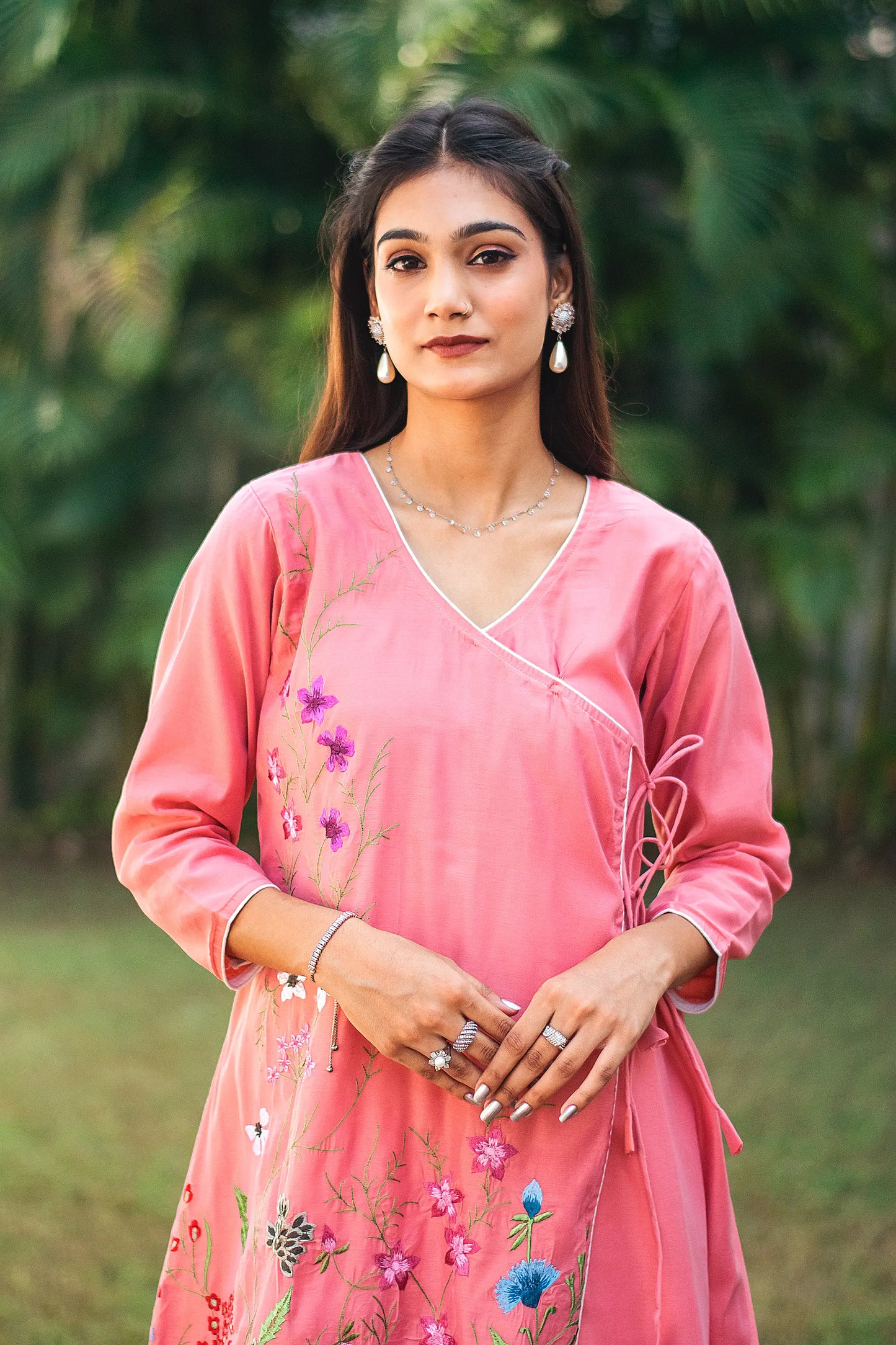 Upper half front view of a model wearing the pink chanderi kurta set, featuring a pink chanderi angrakha.