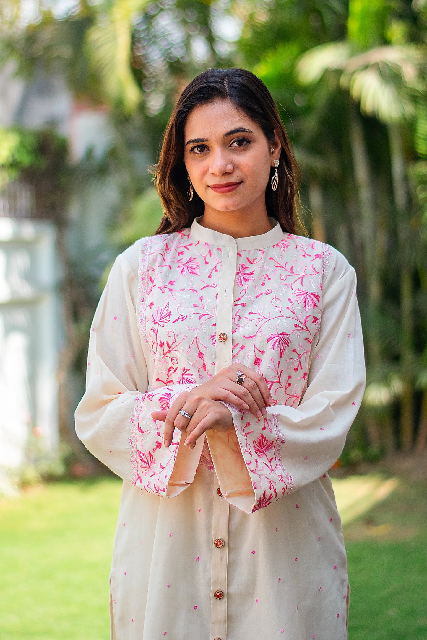 Close-up of an Indian model, highlighting the pink floral Kashmiri embroidery on the yoke of the kurta.