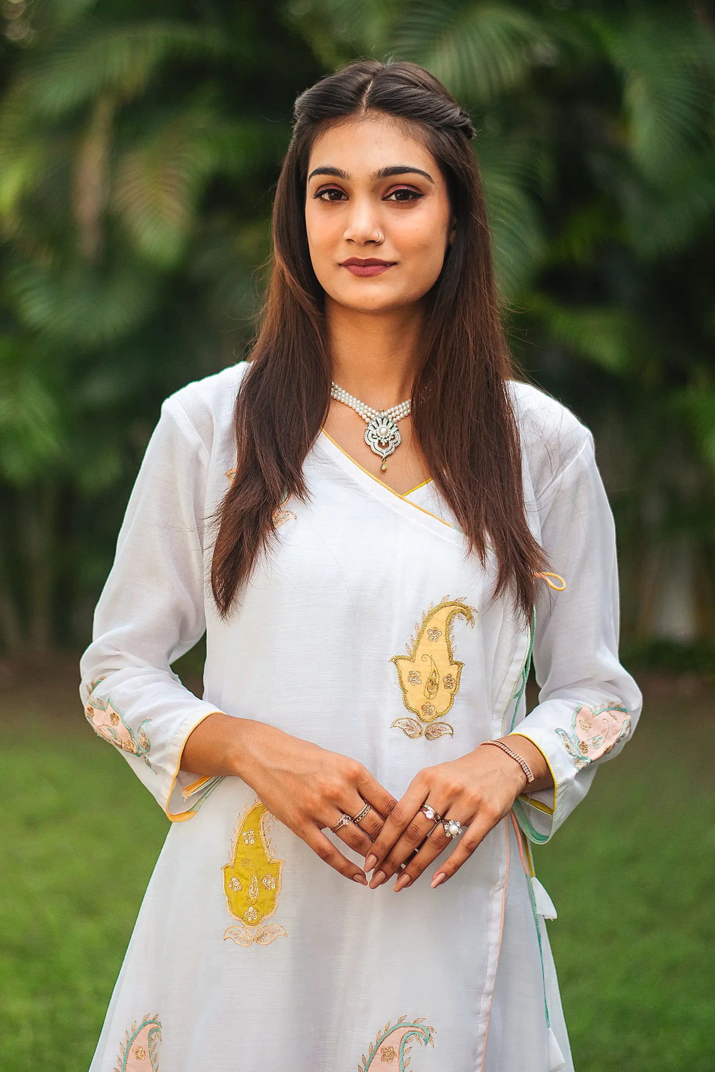 Close-up of an Indian model in a white chanderi angarkha kurta, focusing on the kairi (paisley) patchwork on the yoke.