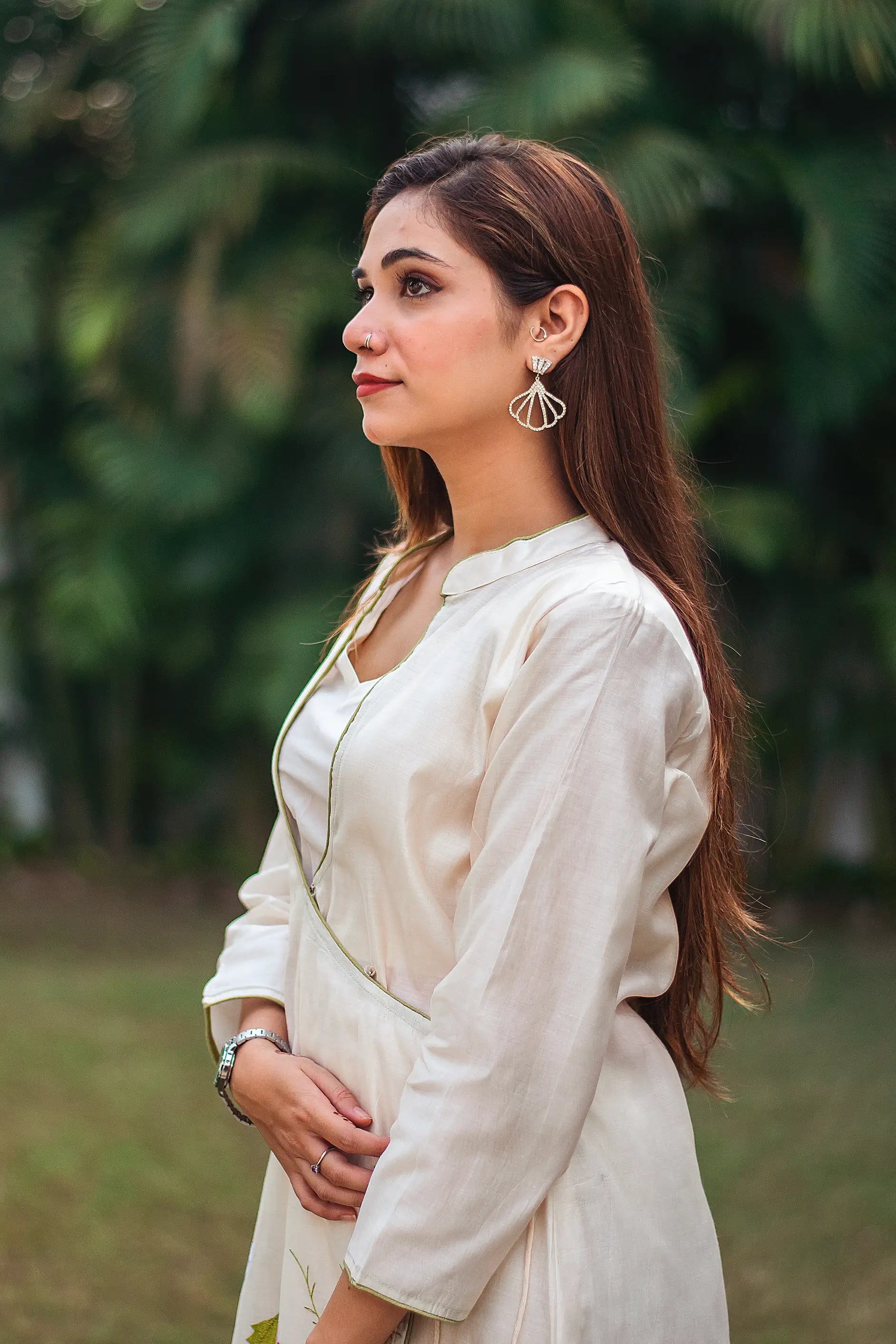  Side view of an Indian model in an off-white angrakha kurta with multicolored floral resham embroidery.