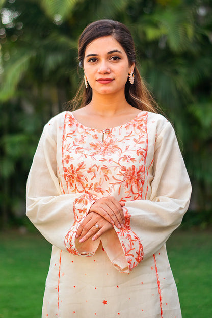 Close-up of an Indian model, focusing on the peach floral Kashmiri embroidery on the yoke of the off-white kurta.