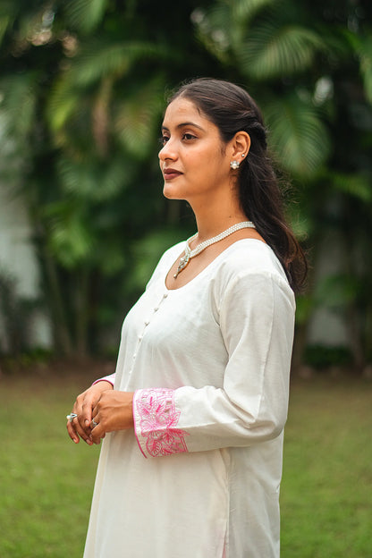 Side profile of an Indian model wearing an off-white chanderi kurta with pink cutwork and scattered sequins.