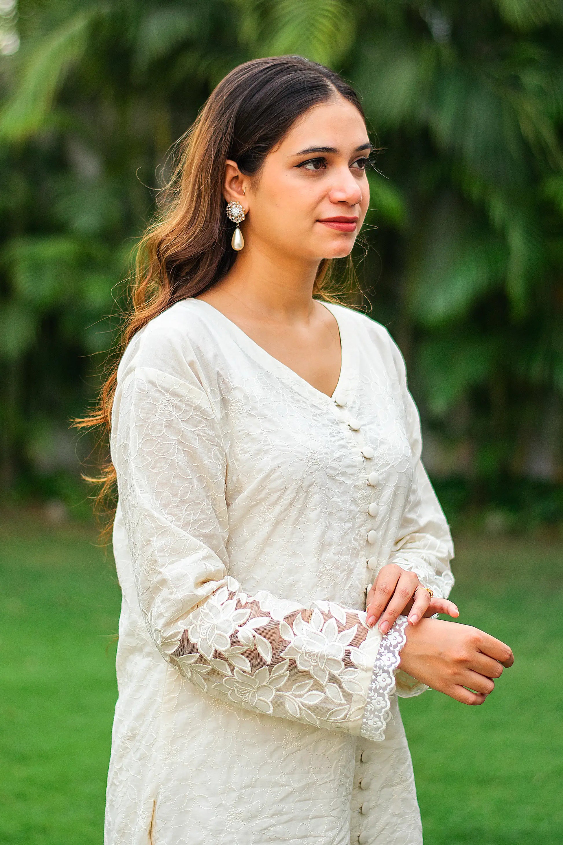 Indian model in a side profile, highlighting the white cutwork kurta with full sleeves.