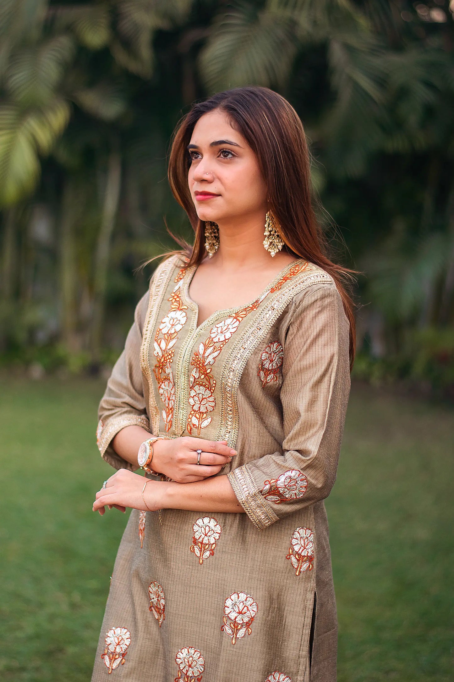  Side view of an Indian model in a beige Chanderi kurta adorned with golden gota patti work.