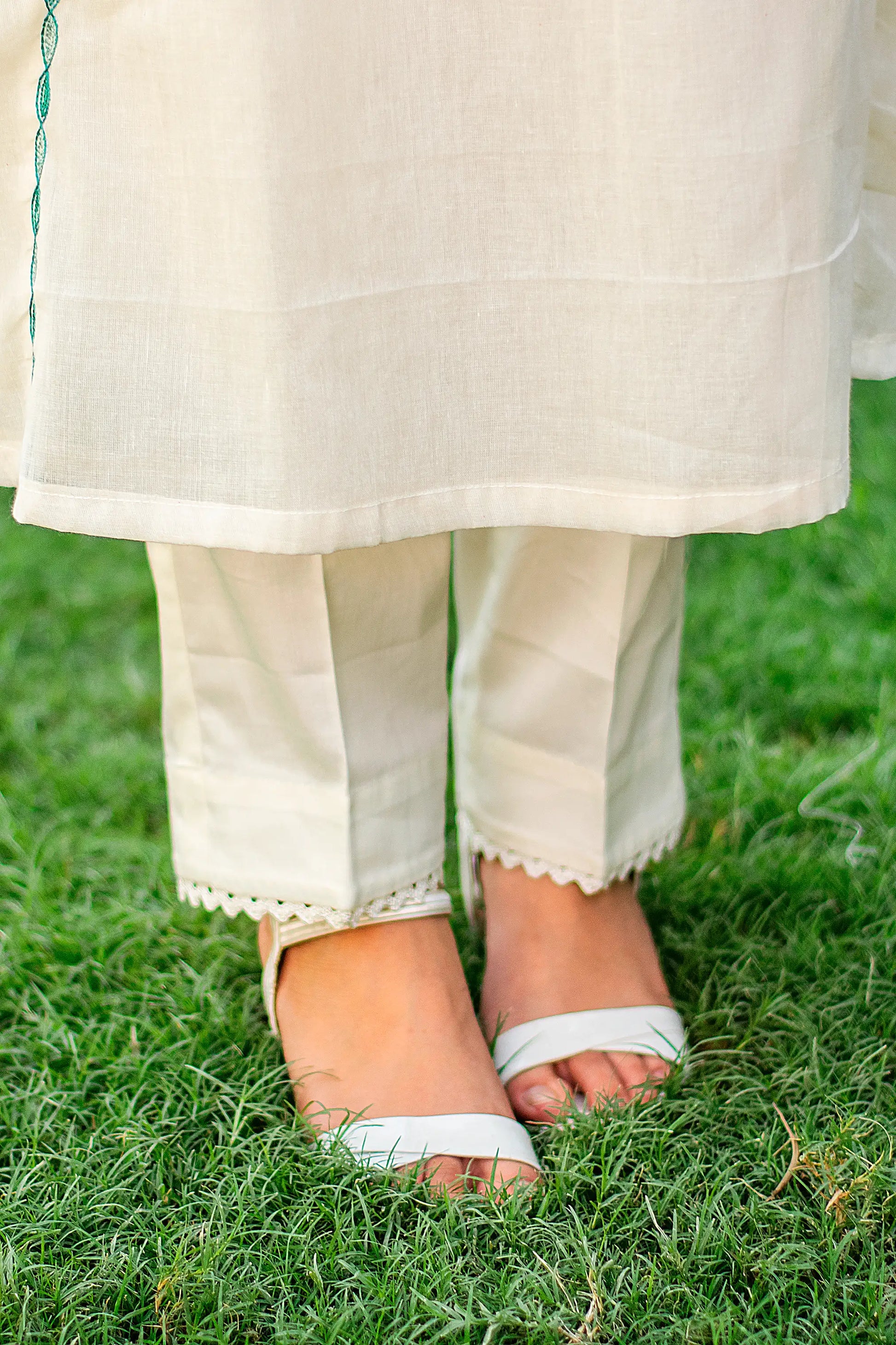 Close-up of an Indian model in plain off-white cotton trousers, part of the Kashmiri embroidery kurti set.