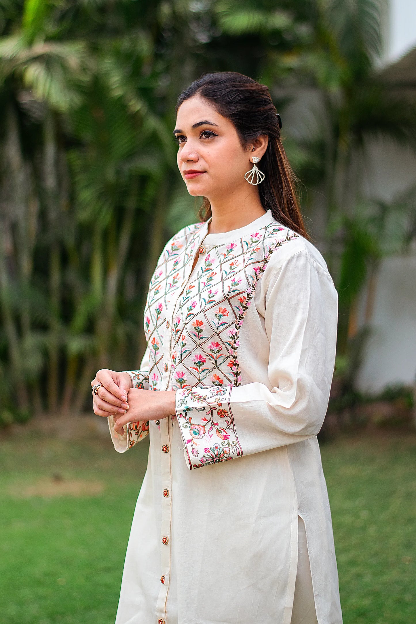 Close up of an Indian girl showing a side pose in an off-white cotton kurti with Kashmiri embroidery