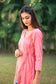 Upper left side view of a model wearing the pink chanderi kurta set, highlighting the angrakha’s silhouette.
