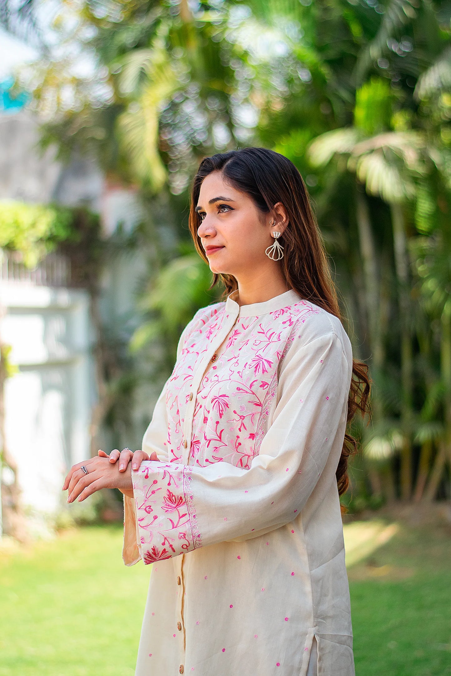  Side view of an Indian model in an off-white Kashmiri kurta with a mandarin collar.