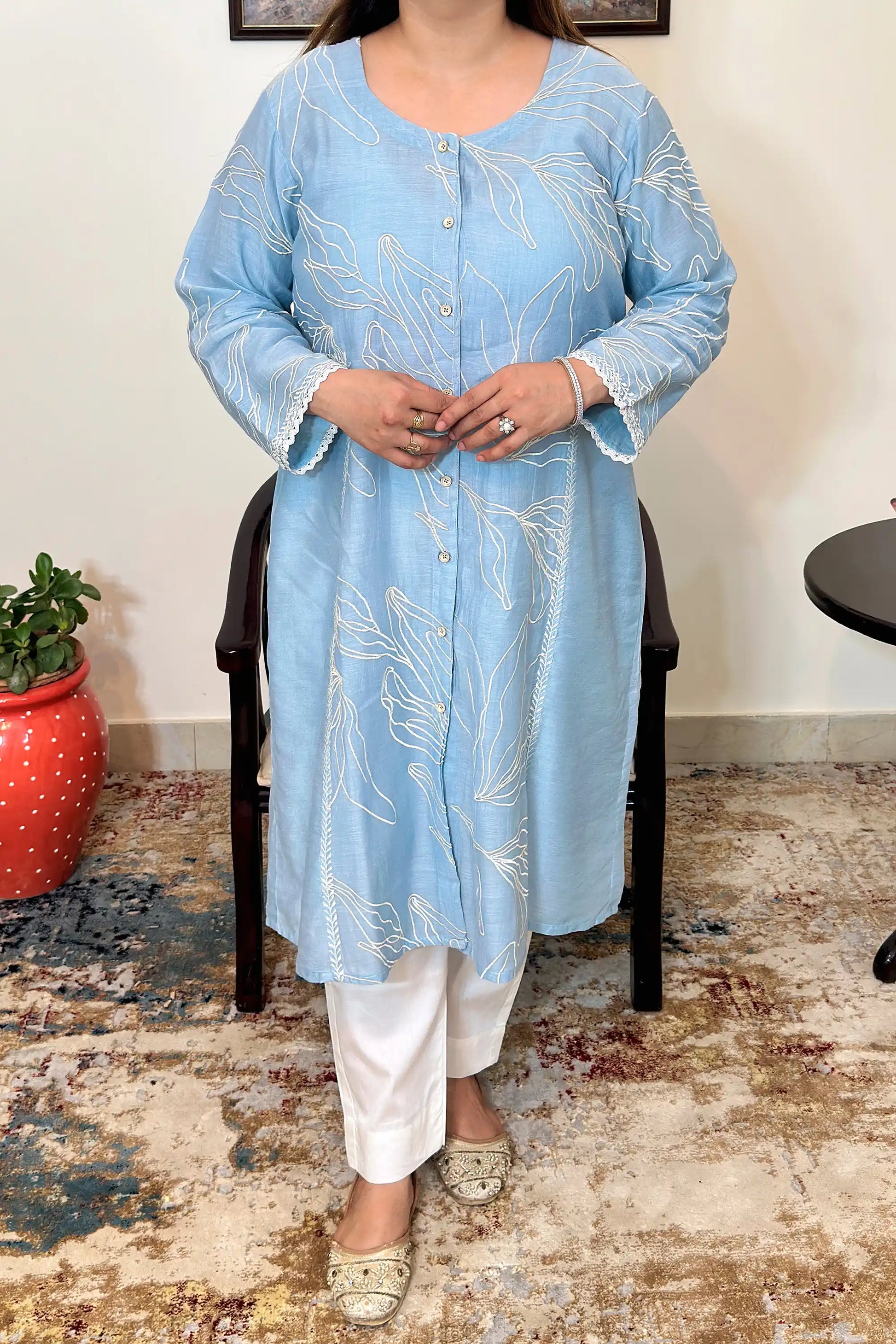 Close-up front view of the blue chanderi A-line kurta with white floral resham embroidery and a button placket, dupatta off.