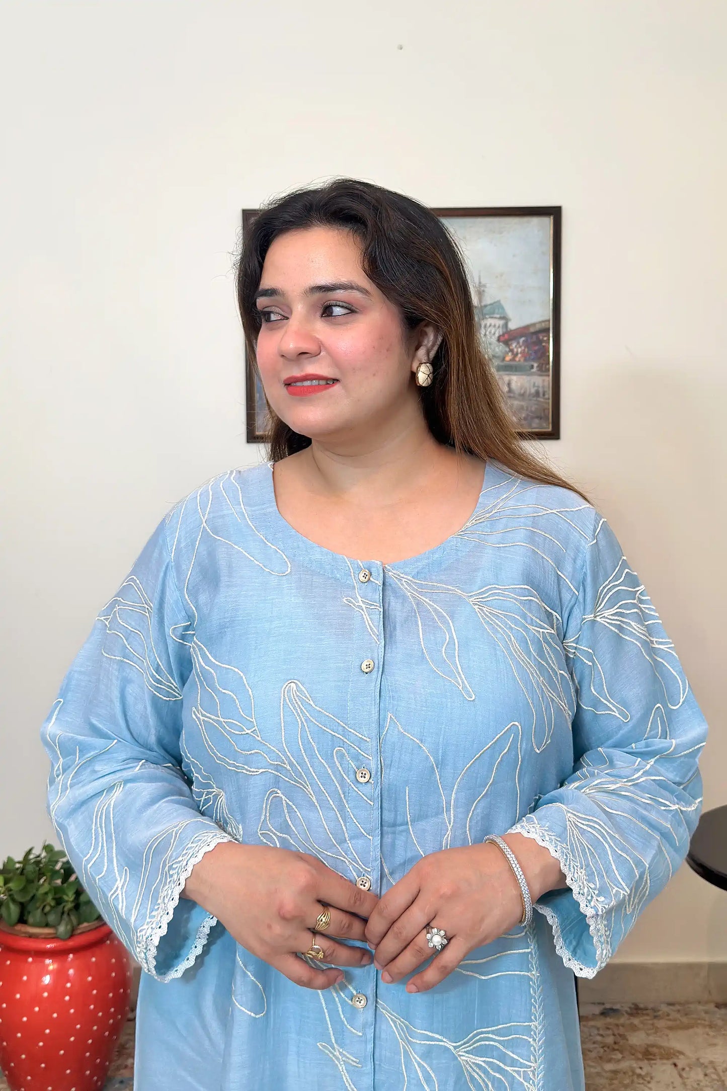 Close-up front view of the blue chanderi kurta with white floral resham embroidery and button placket.
