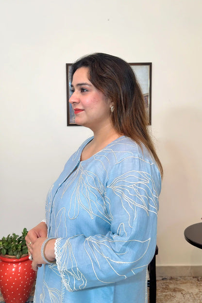 Side view of the blue chanderi A-line kurta with white floral resham embroidery, dupatta off.