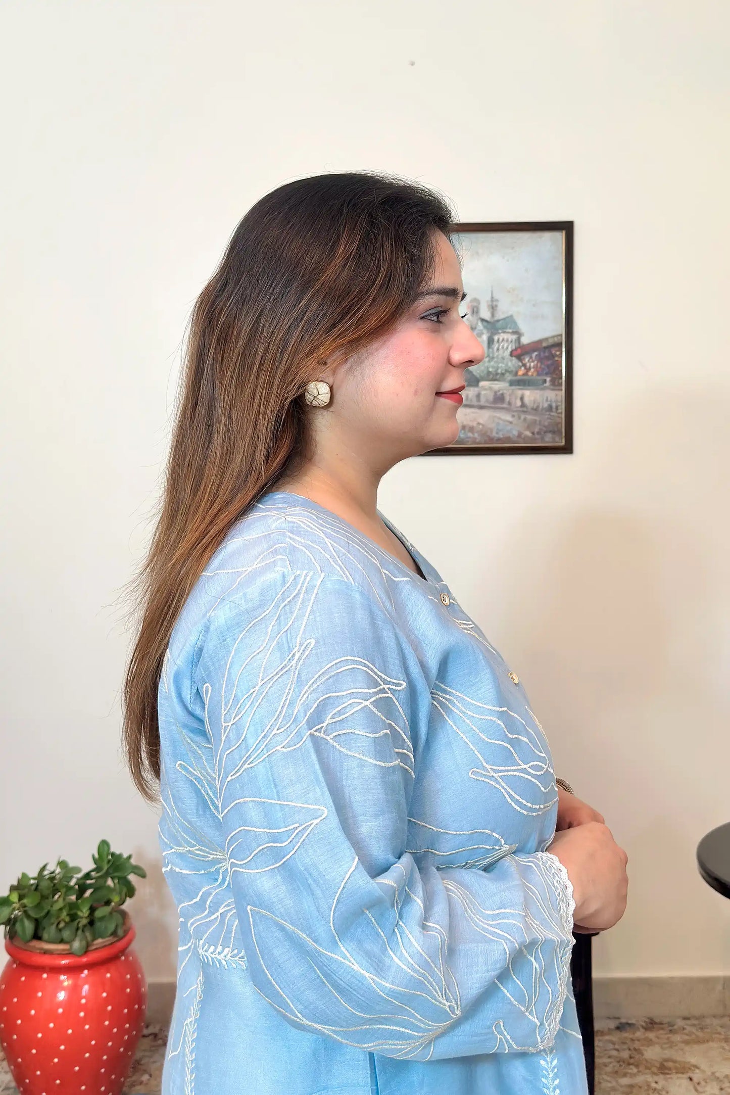 Close-up side view of the blue chanderi kurta with white floral resham embroidery and button placket.