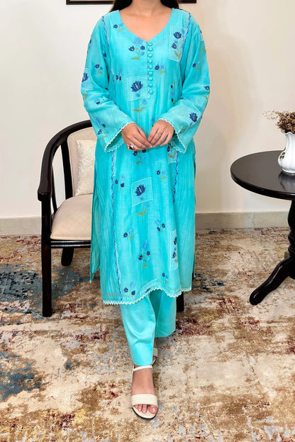 Front view of an aqua-blue chanderi kalidar kurta, featuring blue floral resham embroidery and a button placket, paired with aqua-blue trousers.