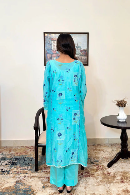 Back view of an aqua-blue chanderi kalidar kurta, featuring blue floral resham embroidery, paired with aqua-blue trousers.