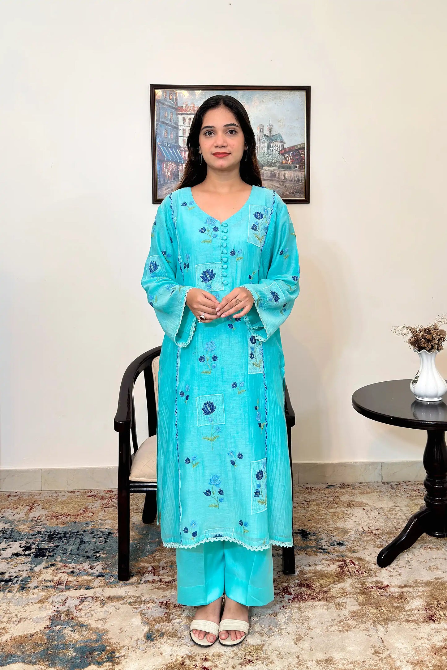 Front view of an aqua-blue chanderi kalidar kurta, featuring blue floral resham embroidery and a button placket, paired with aqua-blue trousers.