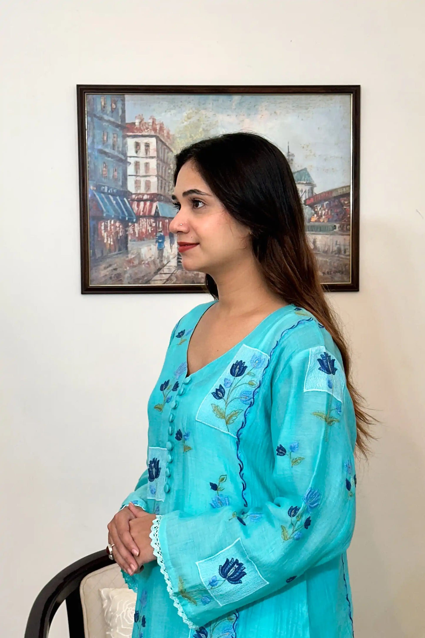 Side view of an aqua-blue chanderi kalidar kurta, featuring blue floral resham embroidery and a button placket.