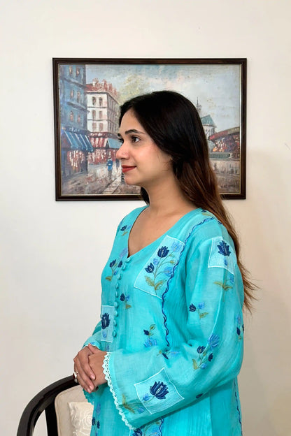 Side view of an aqua-blue chanderi kalidar kurta, featuring blue floral resham embroidery and a button placket.