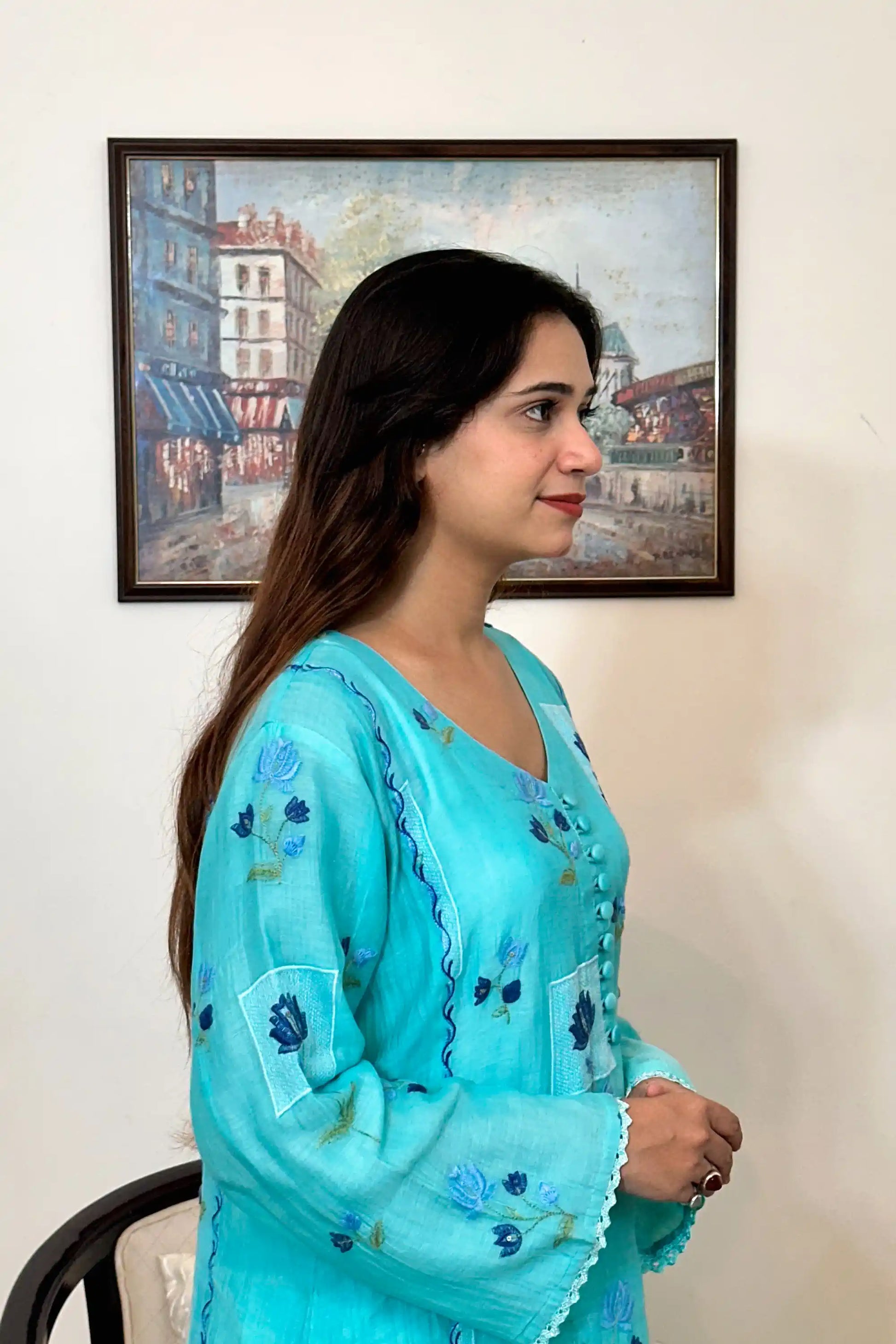 Side view of an aqua-blue chanderi kalidar kurta, featuring blue floral resham embroidery and a button placket.