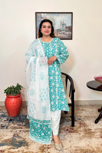 Front view of a woman wearing a turquoise-green mulmul cotton kalidar kurta with an all over white floral print, paired with an off-white printed dupatta with applique work and off-white printed trousers.