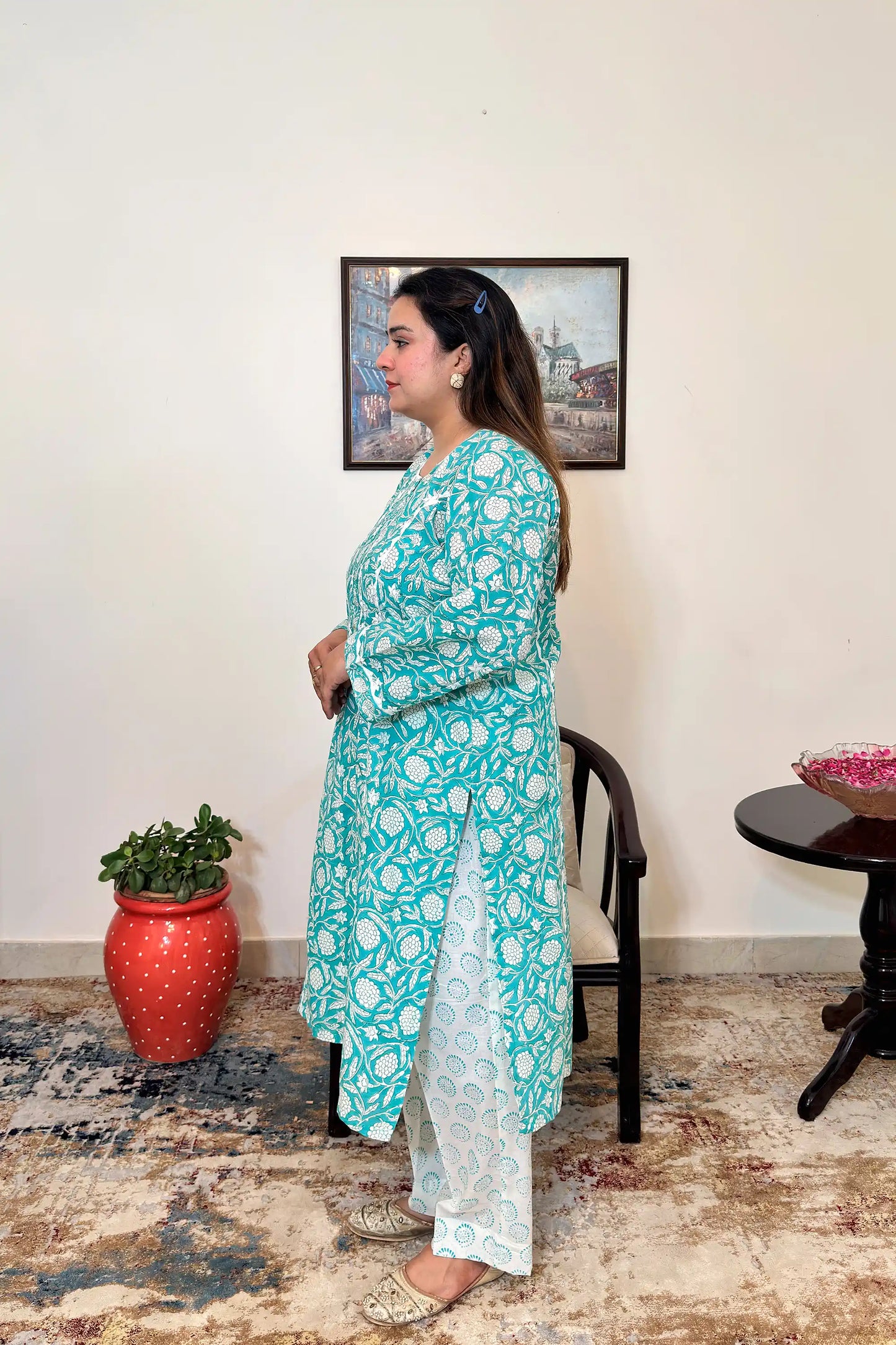 Side view of a woman wearing the turquoise-green printed kalidar kurta with the off-white printed dupatta, showing the straight silhouette and side slit.