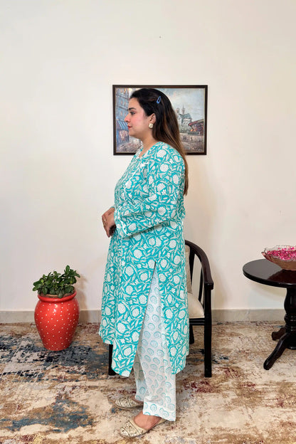 Side view of a woman wearing the turquoise-green printed kalidar kurta with the off-white printed dupatta, showing the straight silhouette and side slit.