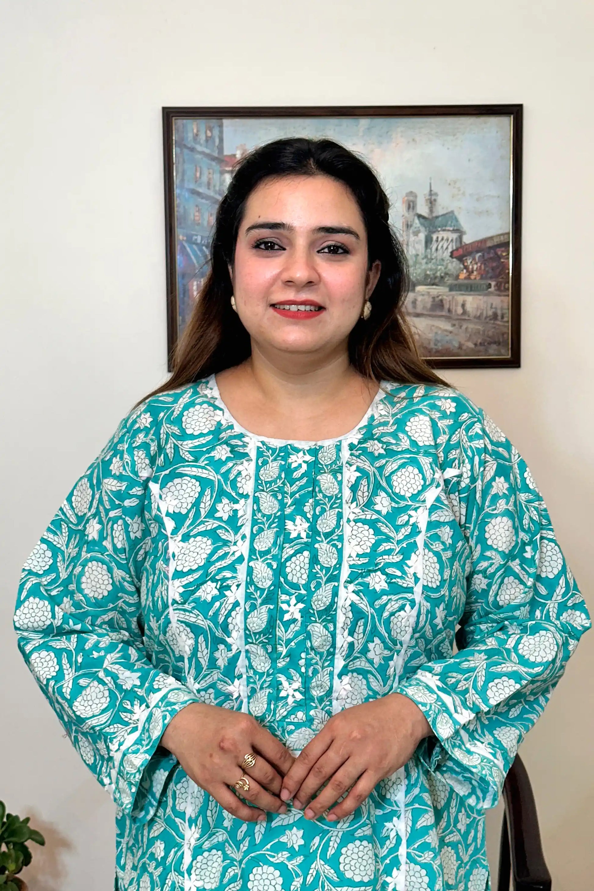 Front close-up of the turquoise-green kurta showing the applique work yoke with white floral print.
