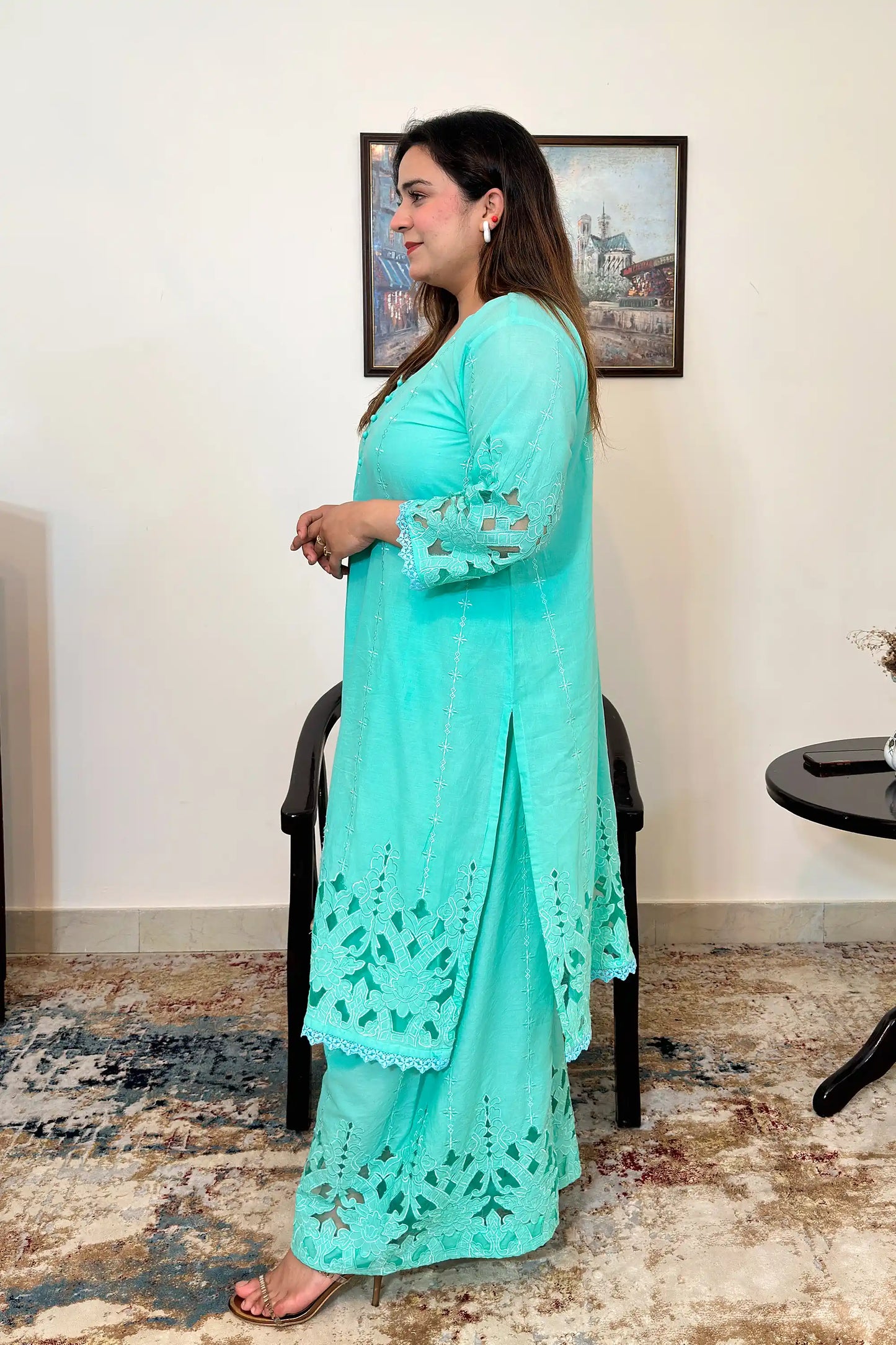 Side view of the aqua-green cotton straight kurta with floral cutwork embroidery and matching aqua-green palazzo.