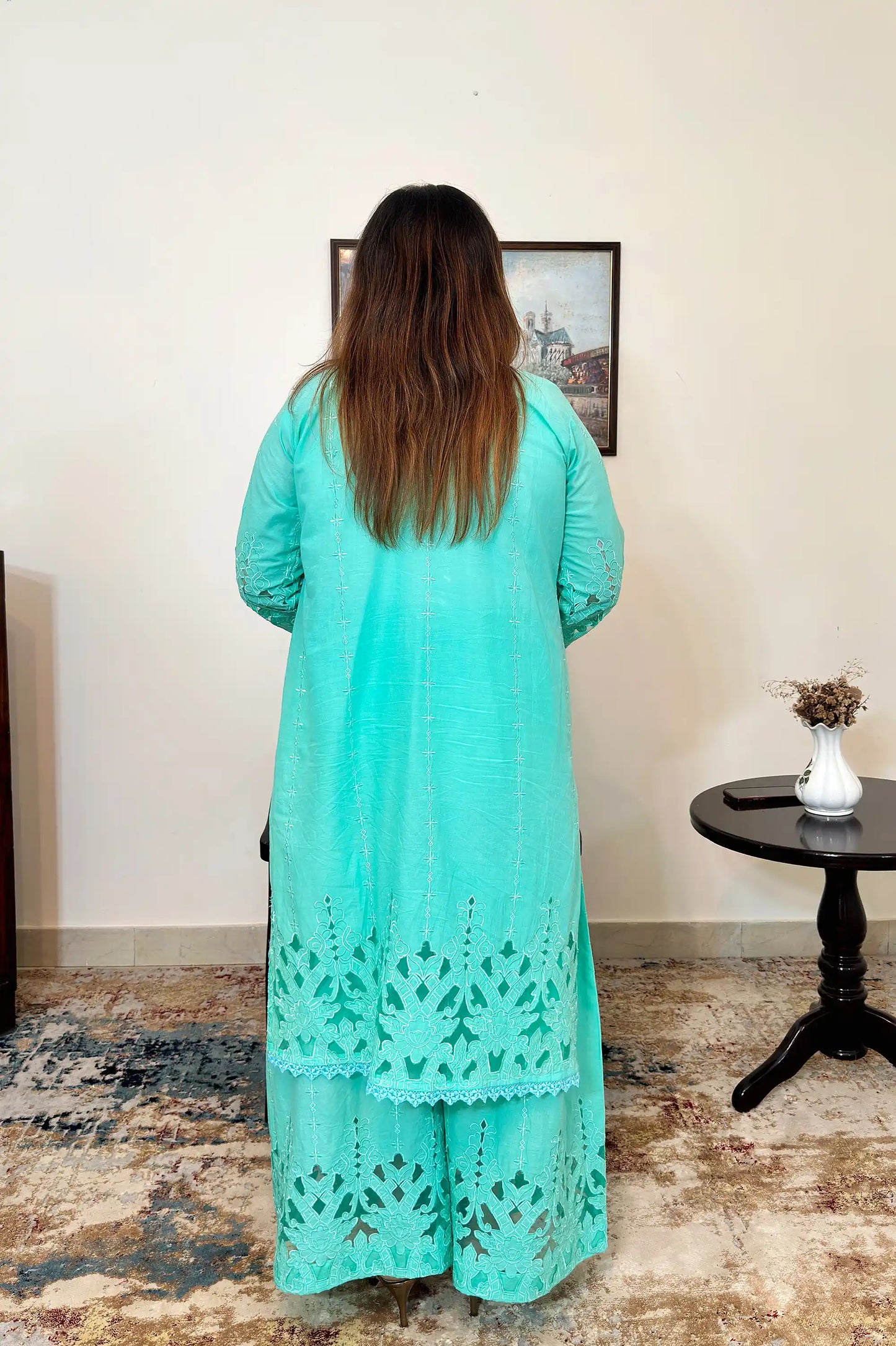Back view of the aqua-green cotton straight kurta with floral cutwork embroidery and matching aqua-green palazzo.