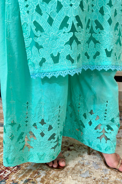 Close-up of the hem of the aqua-green cotton straight kurta and matching palazzo showing floral cutwork embroidery.