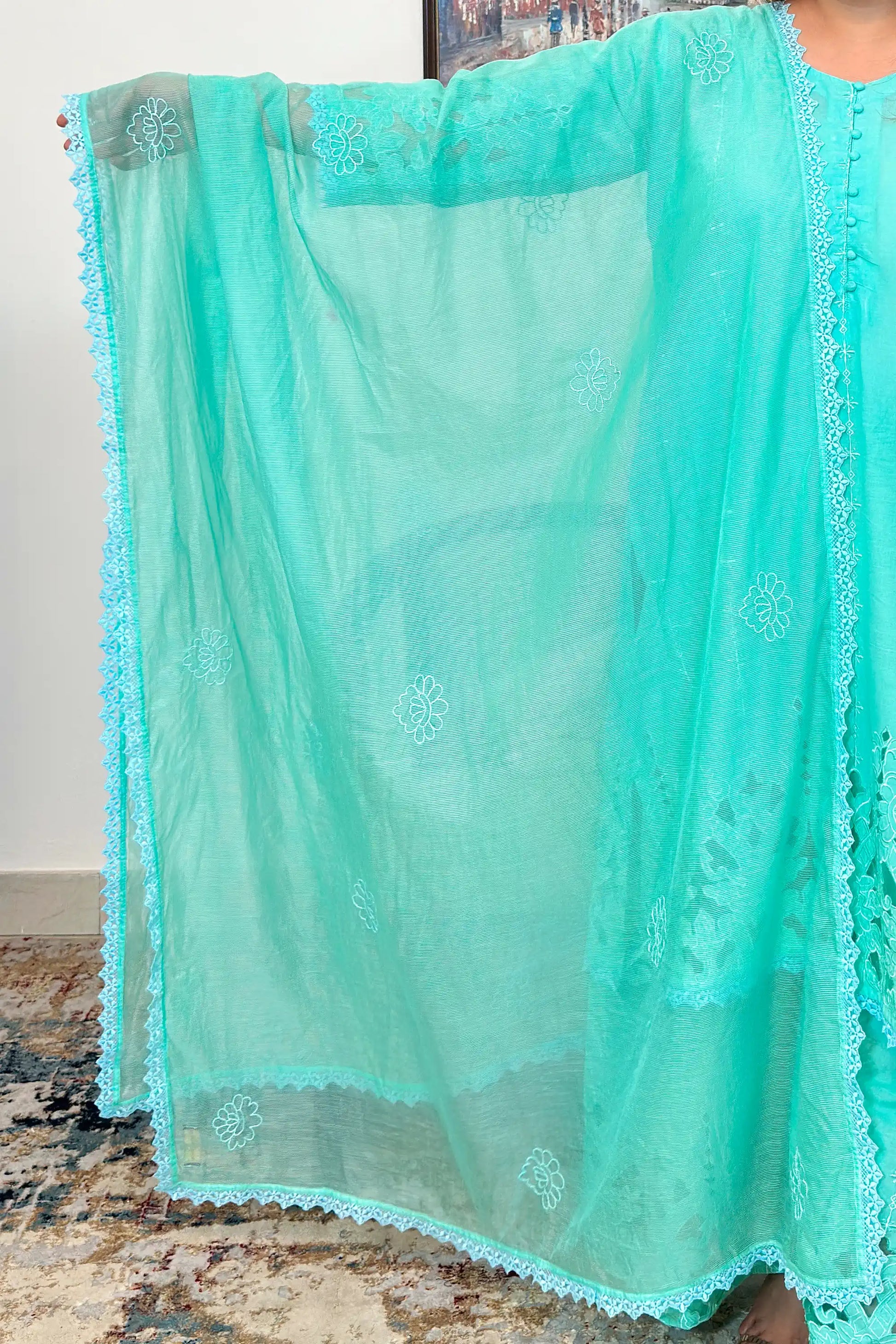 Close-up of the aqua-green net dupatta showing floral embroidery and scalloped lace edge.