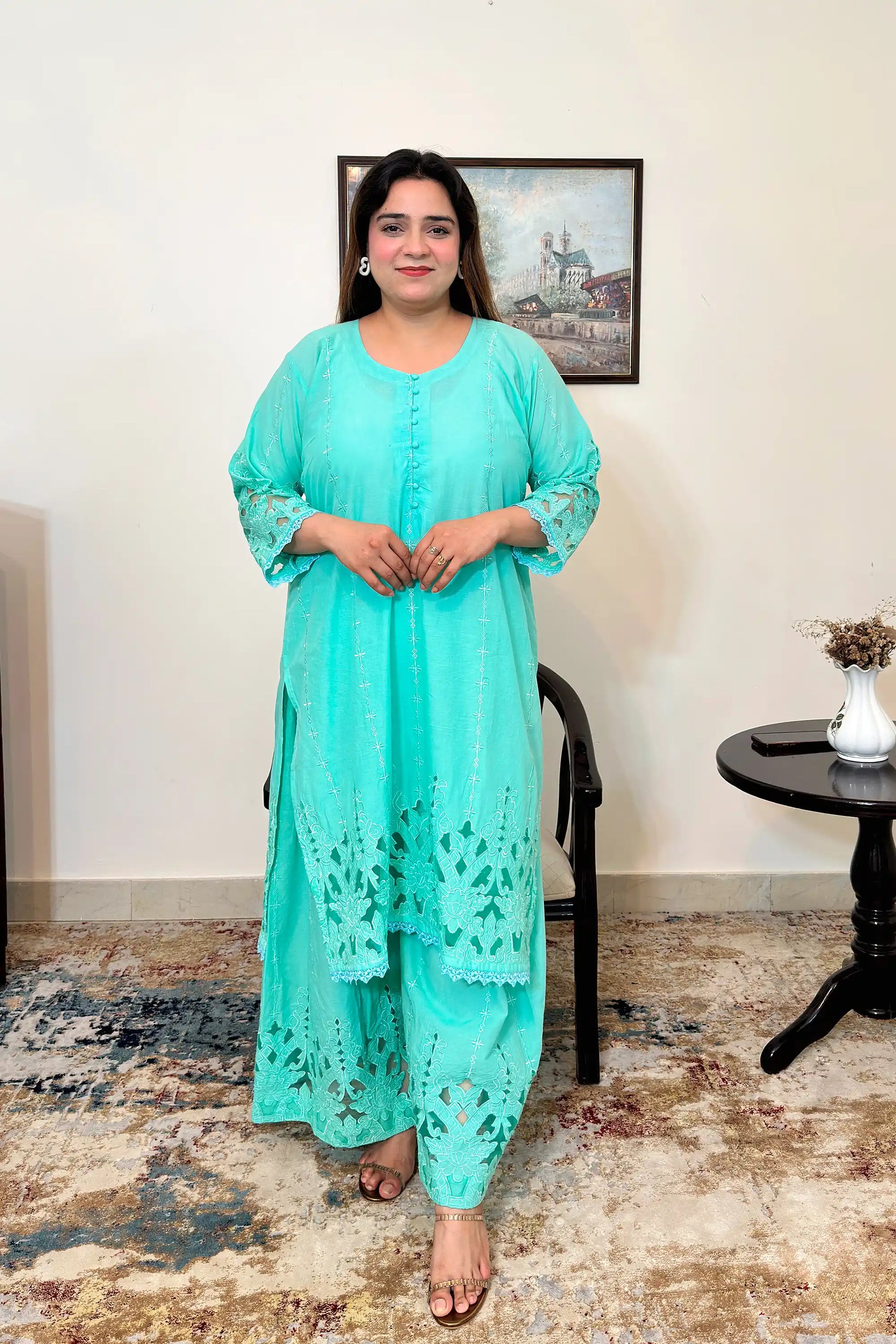 Front view of the aqua-green cotton straight kurta with floral cutwork embroidery and matching aqua-green palazzo.