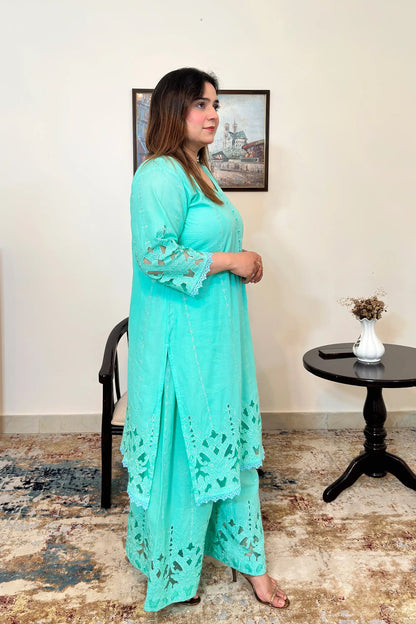 Side view of the aqua-green cotton straight kurta with floral cutwork embroidery and matching aqua-green palazzo.