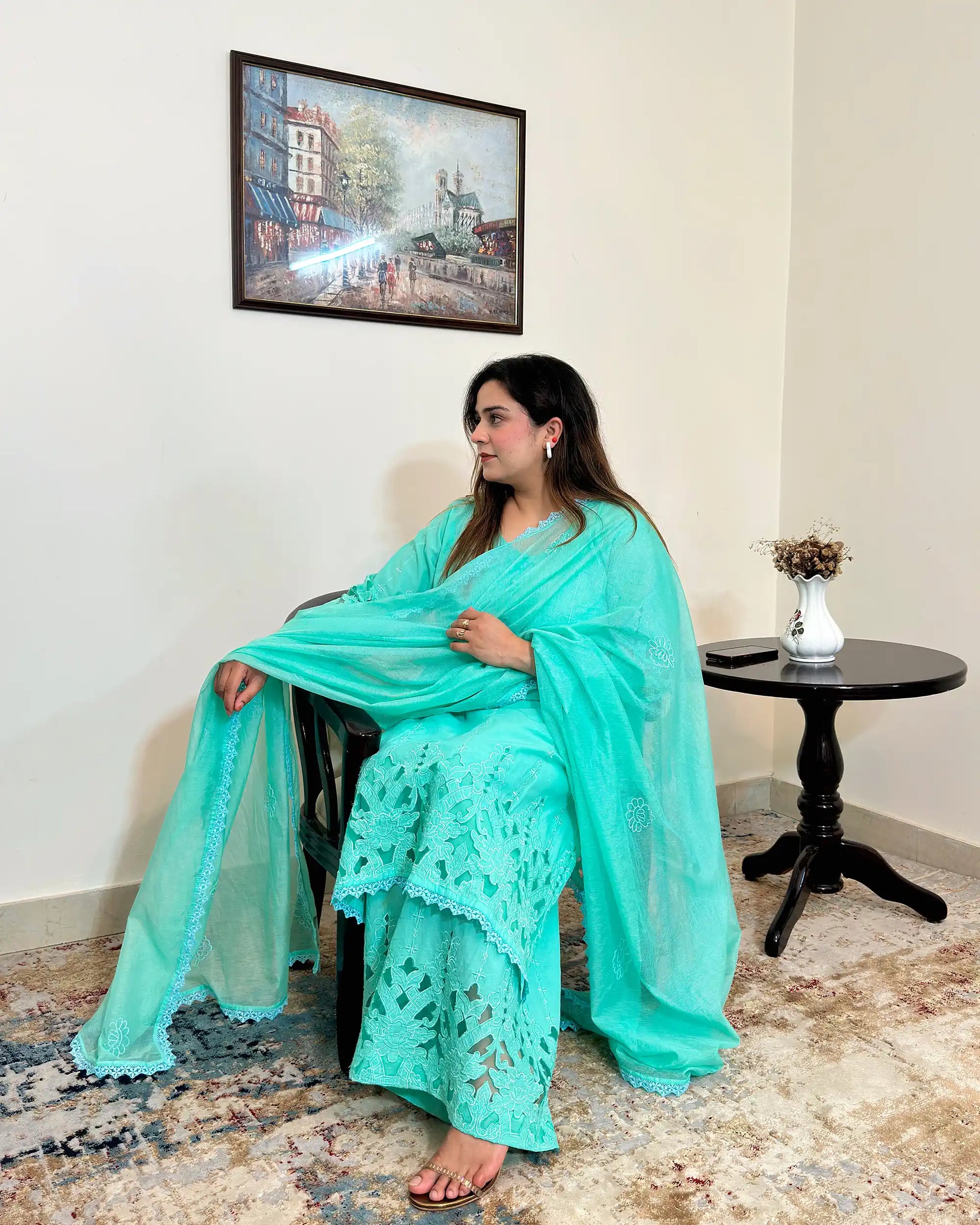 Side view of the aqua-green cotton straight kurta and net dupatta with floral cutwork embroidery, paired with matching aqua-green palazzo.