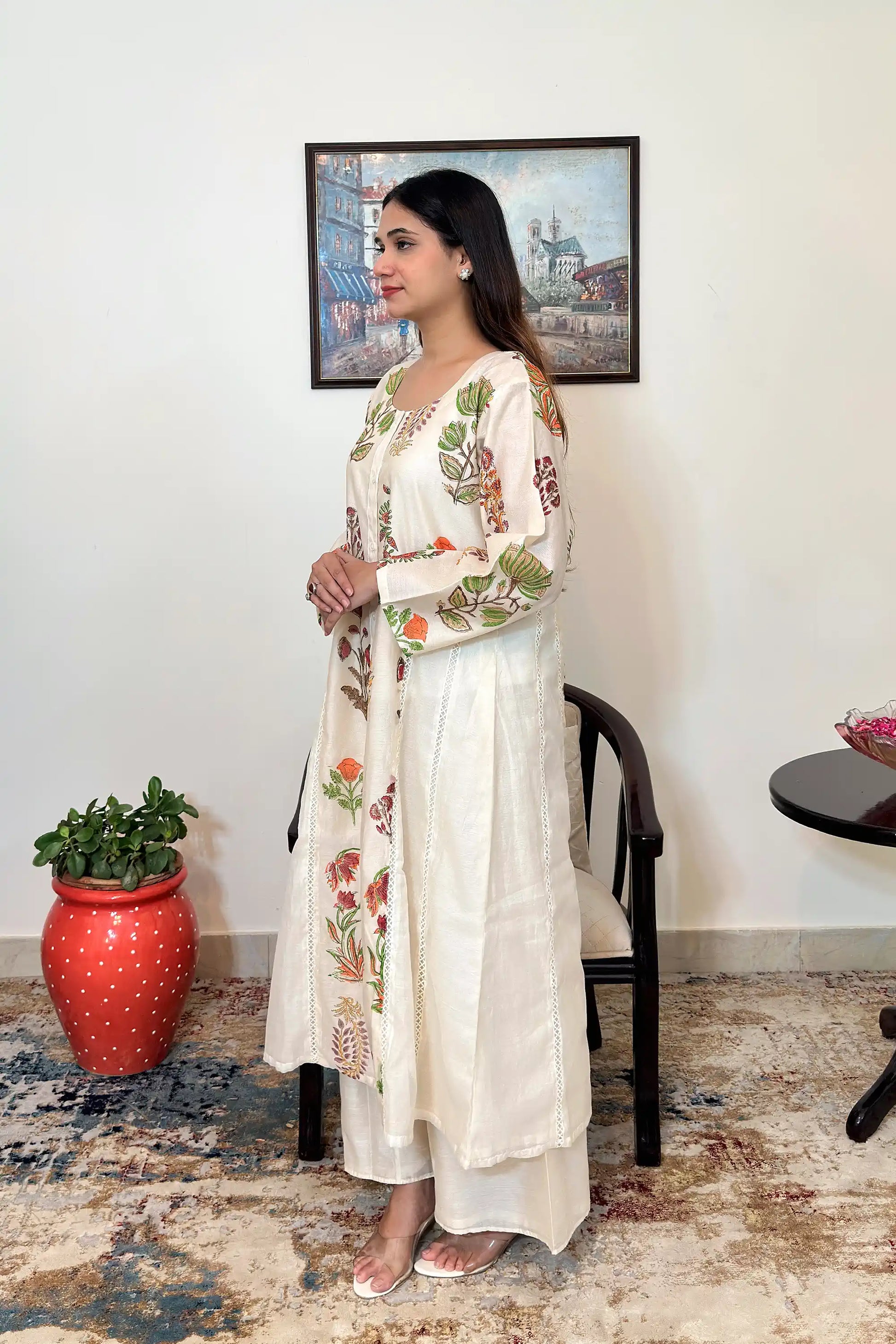 Side view of an off-white chanderi A-line kurta with multicolour floral mughal print, paired with off-white palazzo.