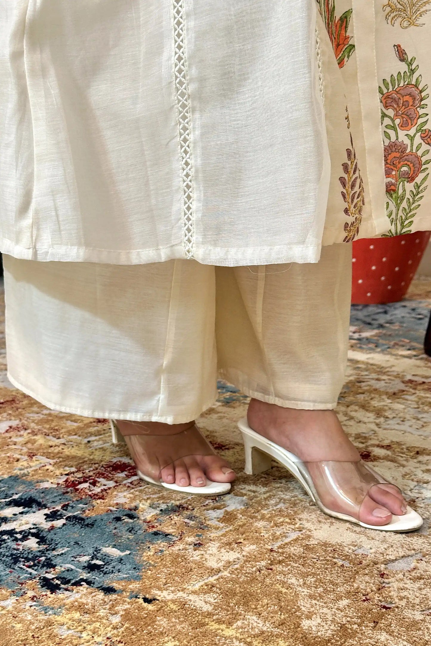 Close-up of the hem of an off-white chanderi kurta over off-white palazzo trousers.