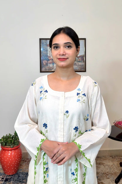 Front view of the off-white chanderi kurta's upper half, showing scattered blue floral embroidery and two white circular embroidered motifs with blue flowers at the neckline and chest.