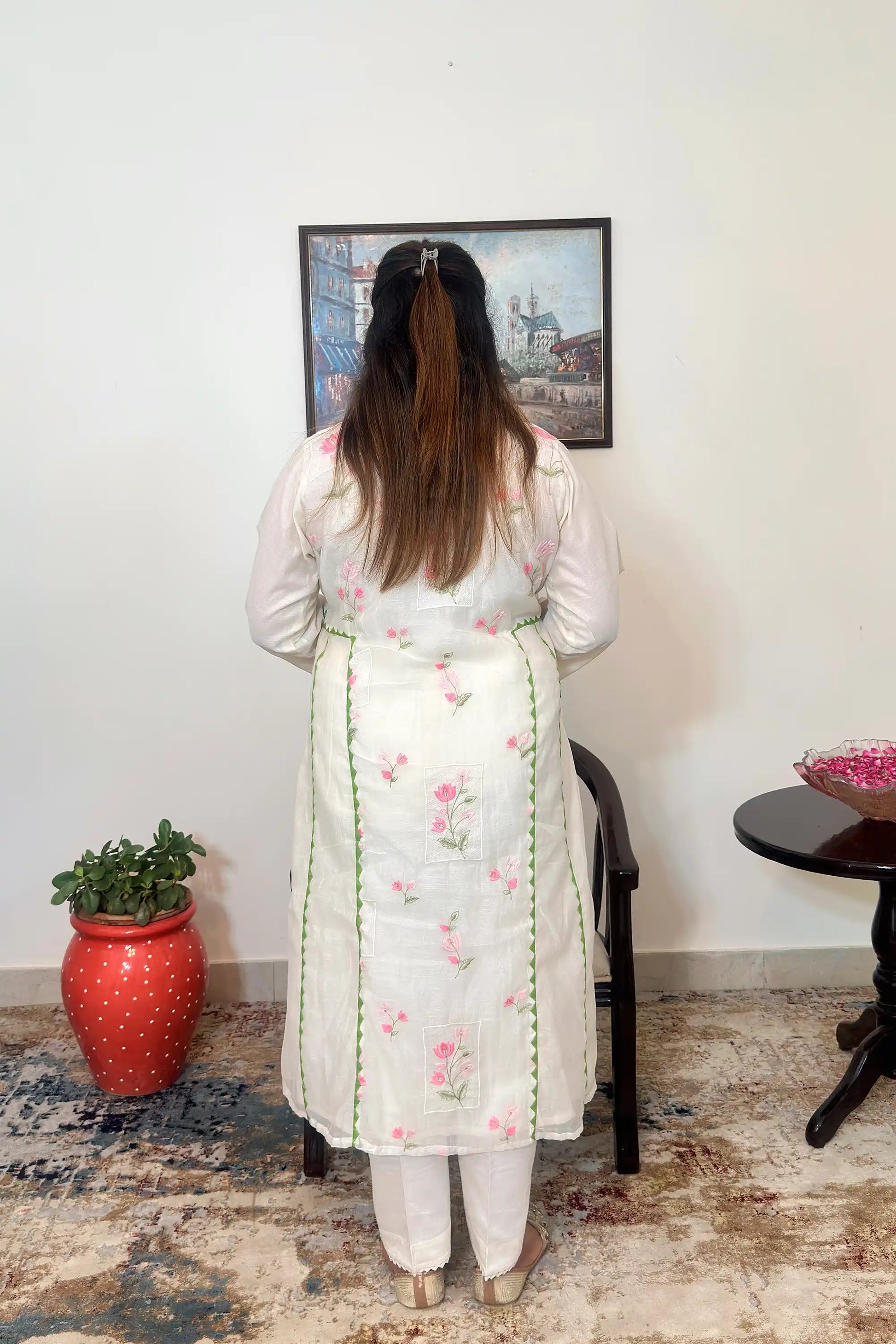 Back view of the off-white chanderi A-line kurta with pink floral embroidery and green applique vine, dupatta off.