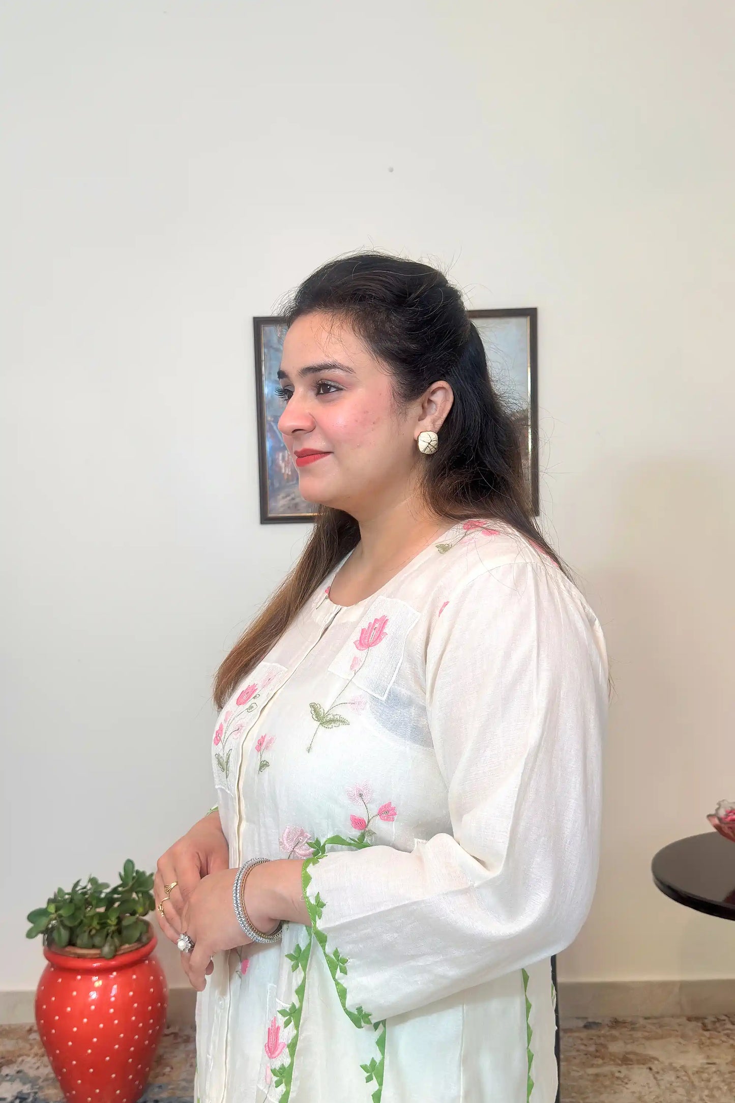 Side view close-up of the off-white chanderi kurta showing pink floral embroidery and green applique.