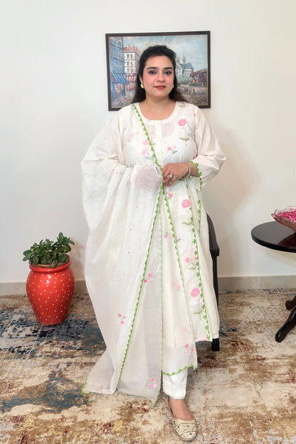 Front view of the off-white chanderi A-line kurta and dupatta with pink embroidery and green applique work, worn with off-white trousers, dupatta on.
