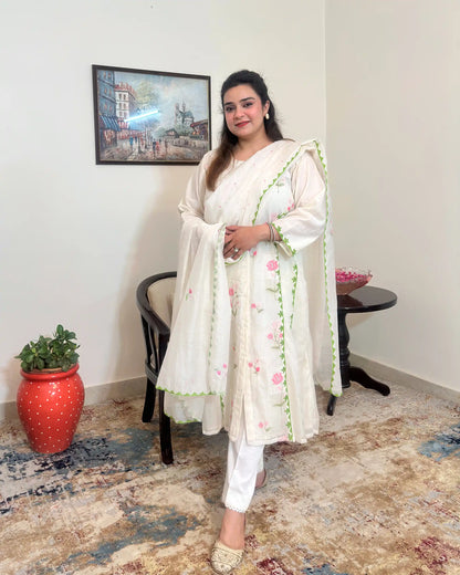 Front view of the off-white chanderi A-line kurta and dupatta with pink embroidery and green applique work, worn with off-white trousers, dupatta on.