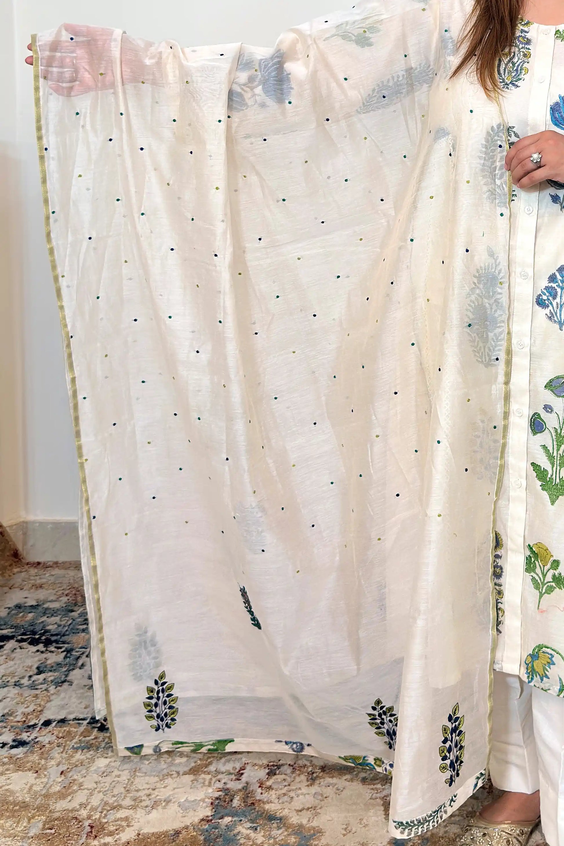Close-up of an off-white chanderi dupatta with scattered embroidered dots and floral hand embroidery along the border.