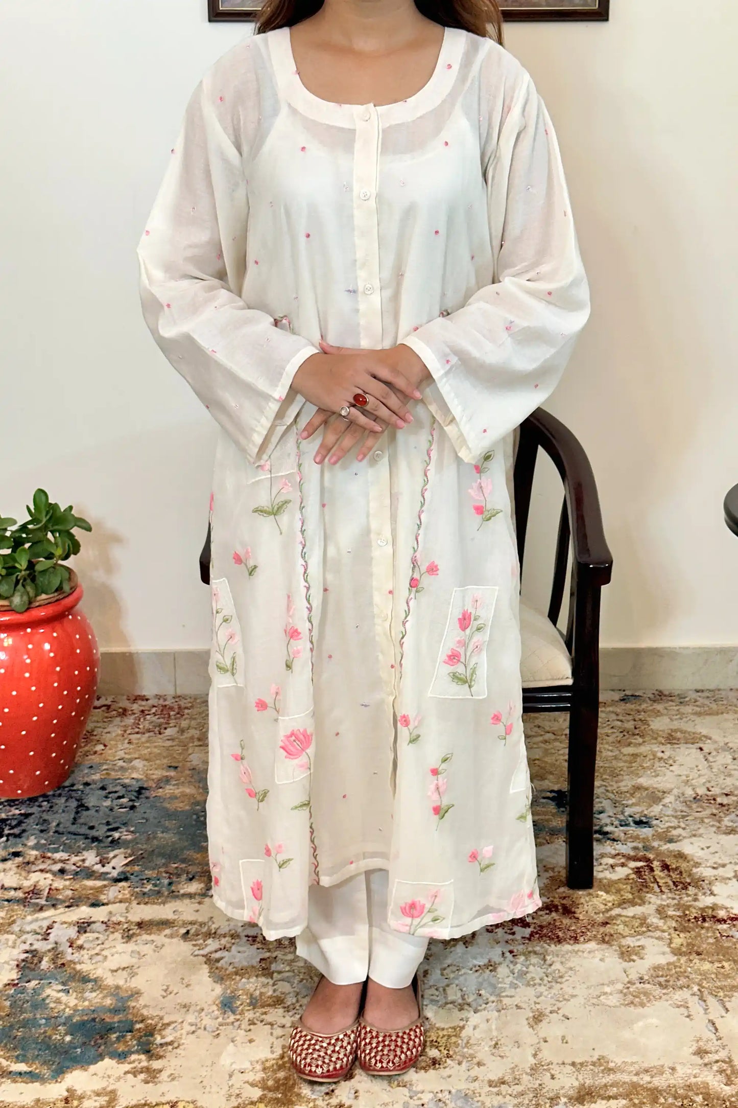 Front view of the off-white chanderi A-line kurta with pink resham floral embroidery down the front panels and embroidered square patches.