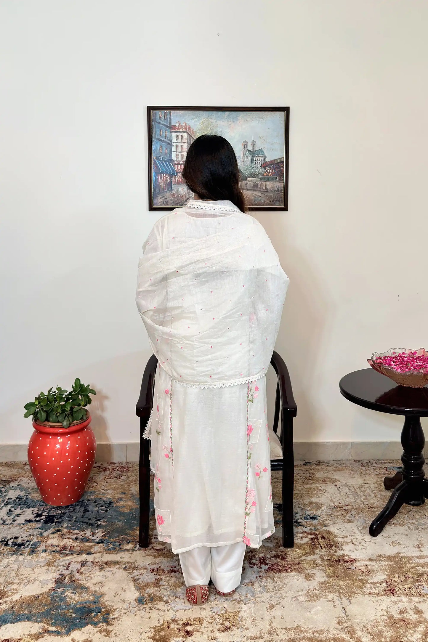 Back view of the off-white chanderi dupatta draped over the A-line kurta, both with pink resham embroidery, worn with off-white trousers.