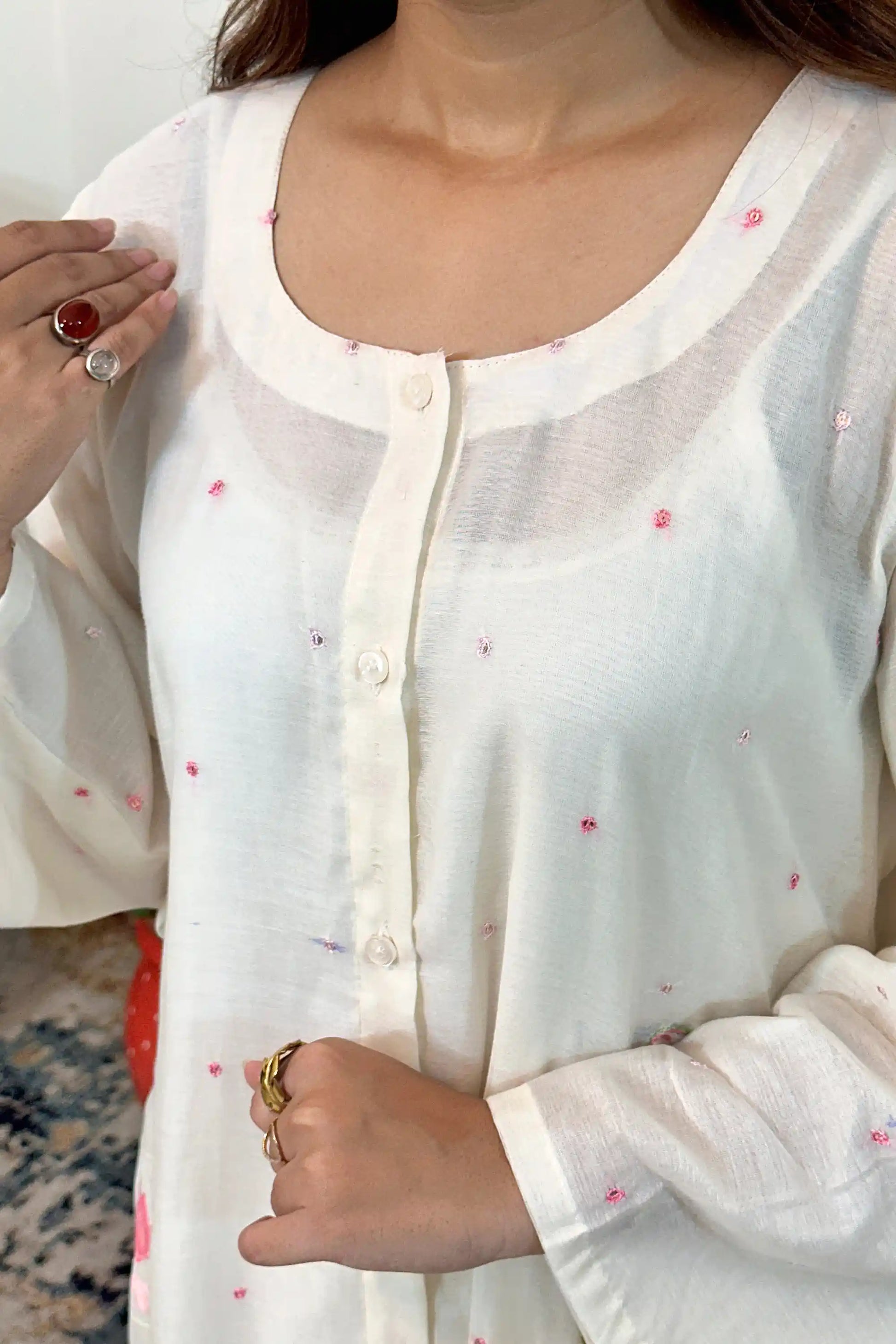 Close-up of the button placket on the off-white chanderi kurta with scattered pink resham embroidery.
