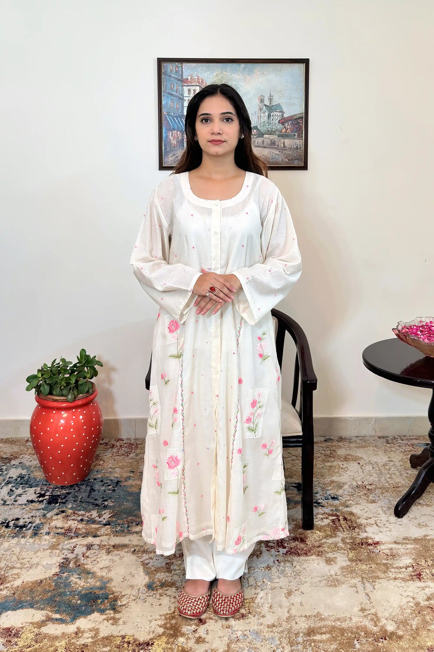Front view of the off-white chanderi A-line kurta with pink resham floral embroidery and off-white trousers.