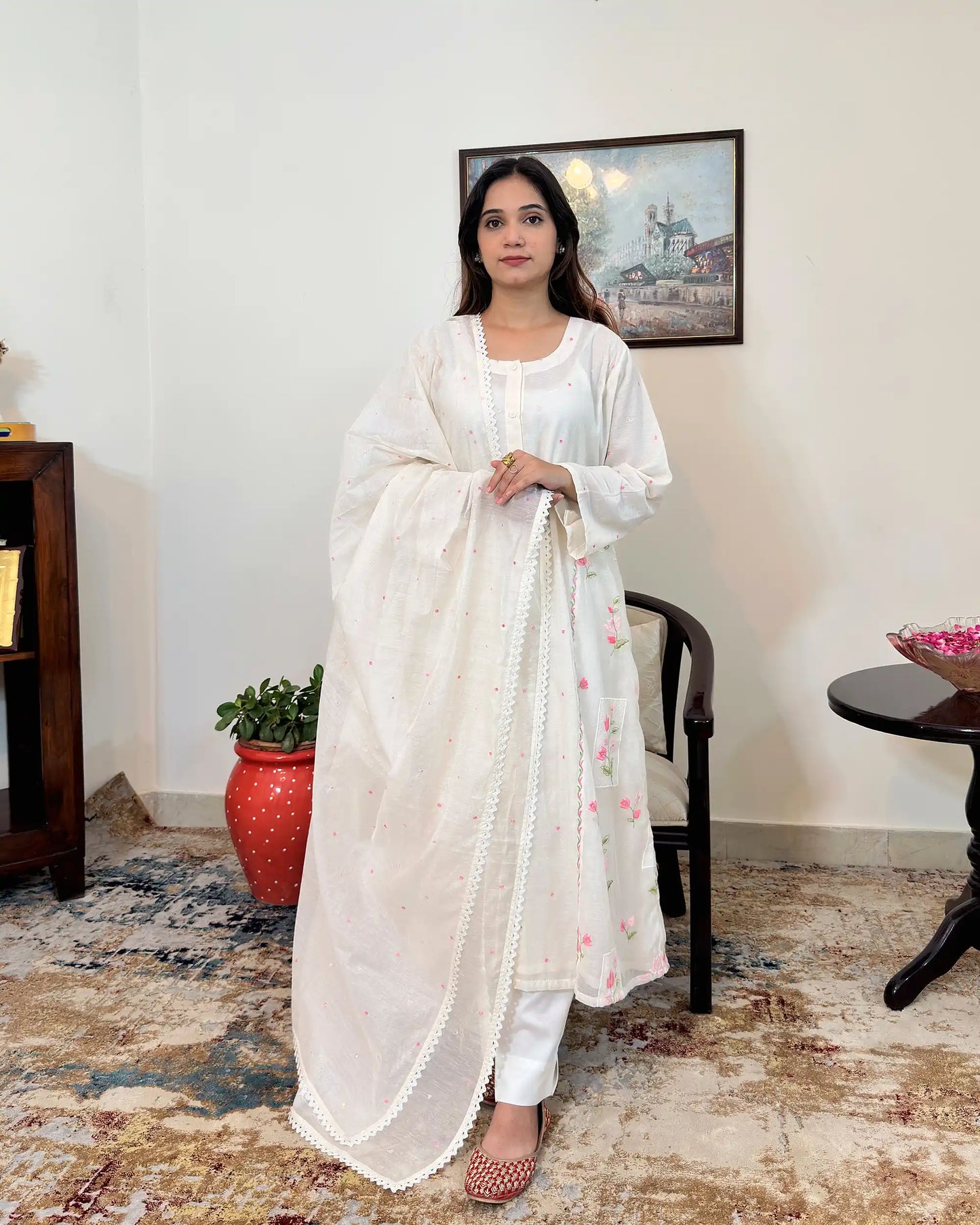 Front view of the off-white chanderi A-line kurta and dupatta, both with pink resham embroidery, worn with off-white trousers.