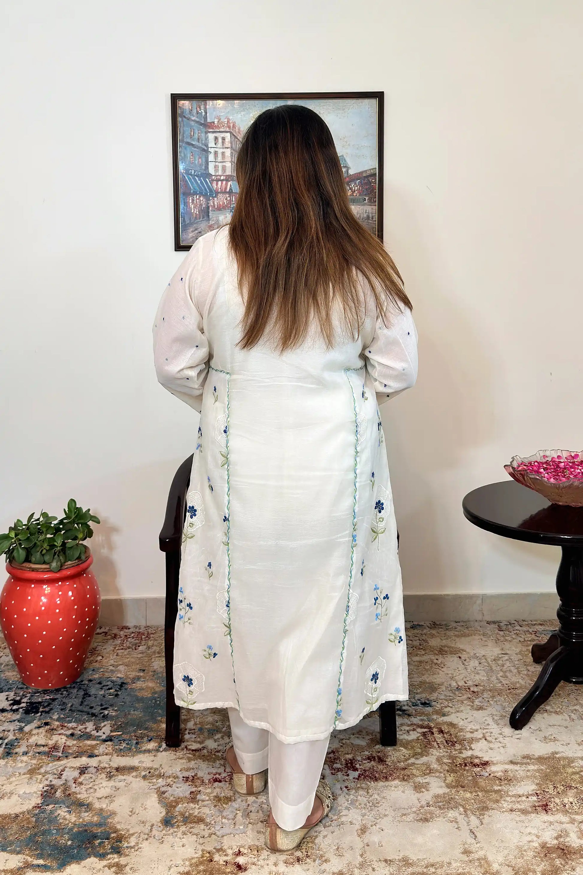 Back view of an off-white chanderi A-line kurta with dupatta off, showing blue floral resham embroidery along the back panels, paired with off-white trousers.