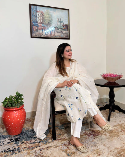 Front view of an off-white chanderi A-line kurta with dupatta on, showing blue floral resham embroidery on the kurta and scattered floral resham embroidery with a lace edge on the dupatta, paired with off-white trousers.