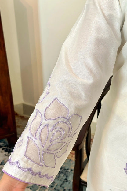 Close-up of the sleeve on the off-white chanderi kurta showing floral cutwork embroidery with purple thread outlining.